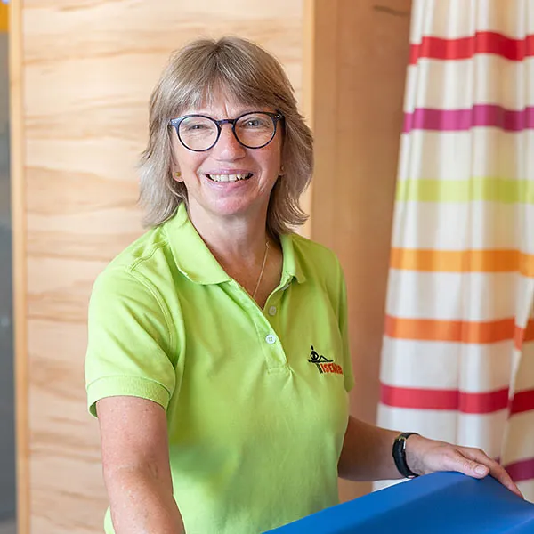 Der Physiotherapeut behandelt die Patientin an der Schulter